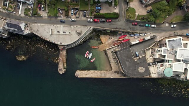 Aerial view of Dalkey Harbour's stone pier and boats juxtapose the dark sea with the colorful boats, in a captivating scene, Dalkey, County Dublin, Ireland.