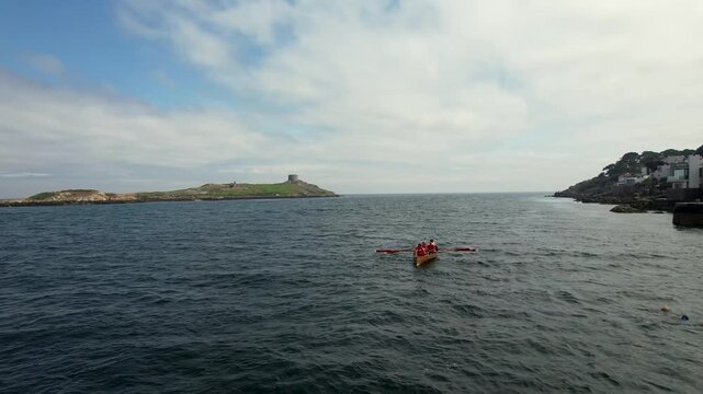 Aerial view of a boat with rowers in the foreground and Dalkey Island with its Martello tower standing proudly against the horizon, Dalkey, County Dublin, Ireland.