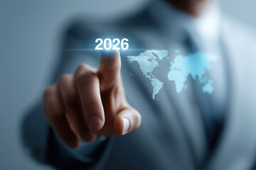 Business hand touches holographic 2026 over glowing world map outline.​