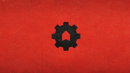 Abstract red background featuring a central black gear symbol, suggesting industry and innovation