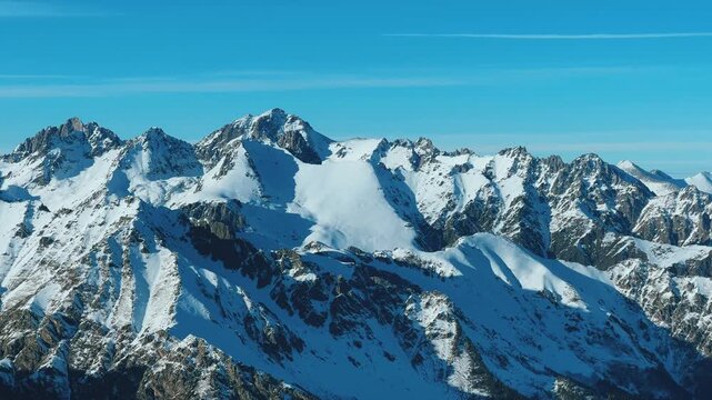 View of Dombay glaciers and mountain peaks in the winter sun. Panorama of the snow-capped Caucasus Mountains in sunny weather. Dombay-Ulgen and Moussa-Achitara mountains. Ski resort in Russia.