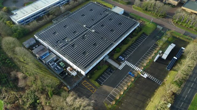Aerial view of a data center with solar panels and a parking lot surrounded by greenery, Milton Keynes, England, United Kingdom.