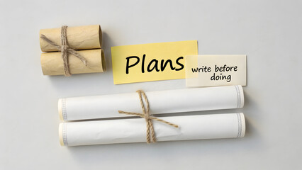 Flat lay of paper scrolls and sticky note with planning text