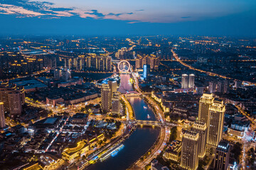 Obraz premium Aerial view of the Haihe River and Tianjin Eye Ferris wheel at night in Tianjin, China.