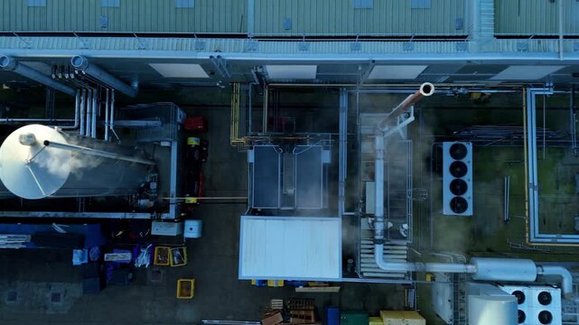 Aerial view of an industrial rooftop, showcasing complex piping and ventilation systems with contrasting textures and tones, Milton Keynes, England, United Kingdom.