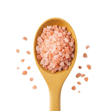 Light brown wooden spoon filled with sparkling pink Himalayan salt crystals, with scattered granules on a transparent background, ultra-macro, direct overhead view, concept of culinary essentialism