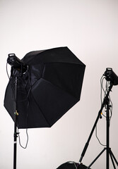 A large black softbox on a stand in a photography studio against a white background