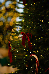 A decorated New Year's tree with lights shining in the evening in a dark room