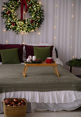 A large bed with a green bedspread is decorated for the New Year.