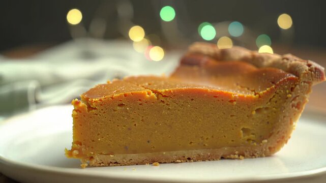 A slice of golden-brown pie with a crumbly crust on a white plate