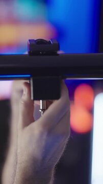 Person mounting clamps on pole between walls on video production set close-up