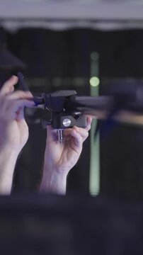 Person mounting clamps on pole between walls on video production set