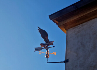 eagle sits on rotating spindle. Because its tail surface area is larger than its head, wind pushes tail away, causing eagle head to point wind.​ Compass Point, made of polished copper 