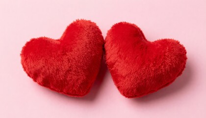 Two fluffy red heart cushions on a soft pink background symbolizing love and affection