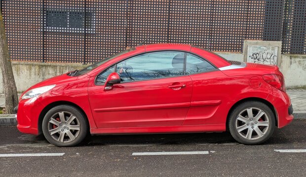 Vista lateral de un autom&oacute;vil Peugeot 207 cabrio aparcado en una calle de Madrid, Espa&ntilde;a, 29 de diciembre de 2025