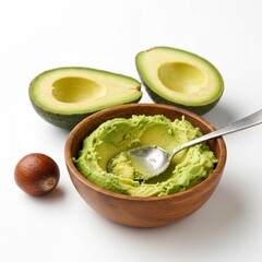 Fresh guacamole in a wooden bowl and green avocados on a white background