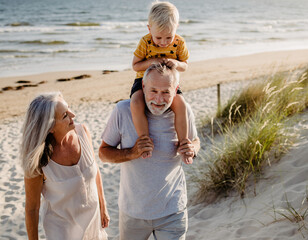 Dziadkowie spacerujący z wnukiem po plaży