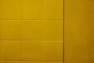 Warm yellow padded wall with subtle square geometry, soft matte fabric texture and gentle surface depth. Clean modern background with tactile feel, minimal visual noise and balanced negative space.