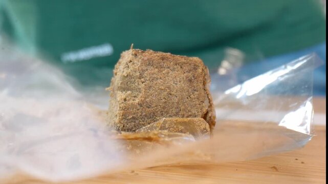 Hashish on a plastic bag fluttering in the wind, Macro shot, slow motion