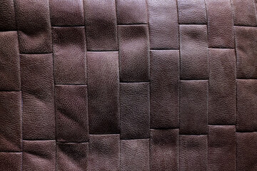 Dark brown woven leather wall with geometric padded pattern and tactile luxury texture. Elegant...