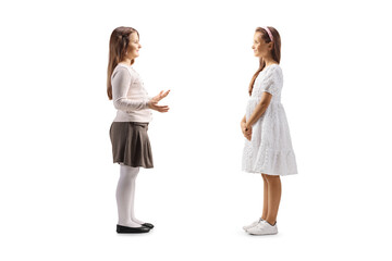 Two young girls having a conversation face to face on white background