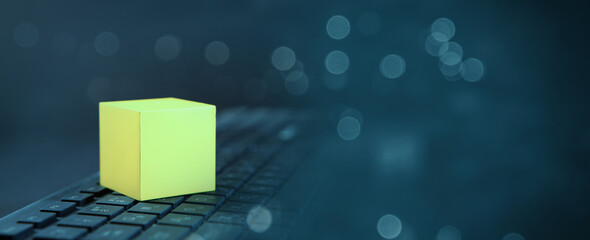 computer keyboard with a yellow cube.