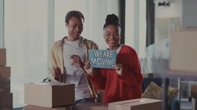 Happy couple organizing belongings together, Energetic partners navigating packing process in lively apartment