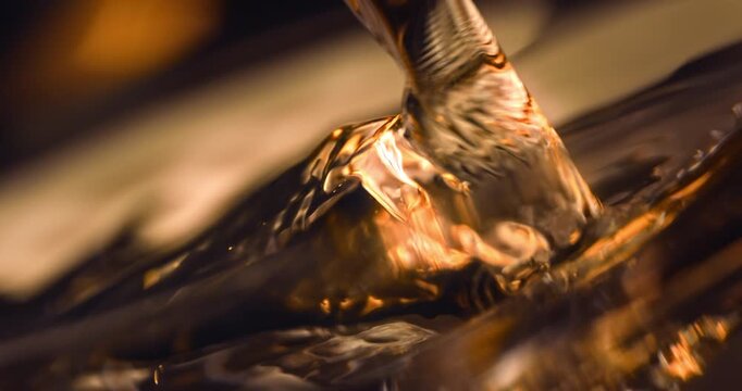 Cinematic macro slow motion at 1000 fps of clear spirits being poured into a martini glass. Elegant blurred bar background, soft intimate lighting, refined mixology, luxury nightlife and premium cockt