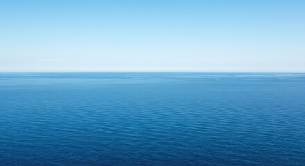 Obraz premium Calm blue ocean stretching into the distance under a bright sky, emphasizing the uninterrupted boundary line and deep, infinite perspective ,deep ,ocean ,summer