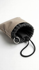 A close-up shot of a beige fabric drawstring pouch with a dark interior, featuring a metal ring and black cord on a white background.