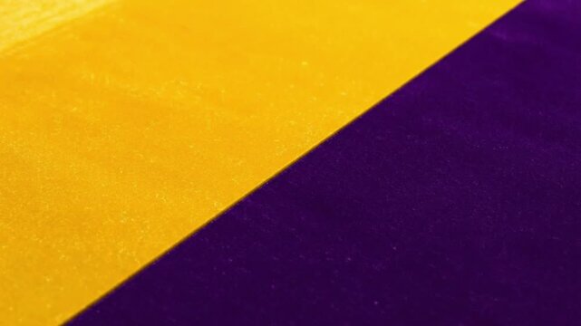 Vibrant yellow and deep purple abstract background with a diagonal split and textured surface, creating a dynamic color contrast.