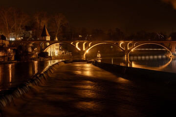 illuminated railroad bridge of Bremgarten is reflecting in the Reuss river