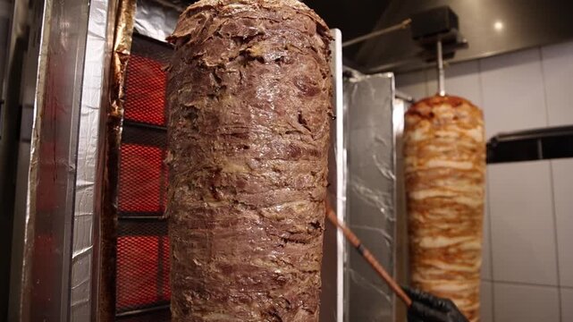 A chef makes shawarma in a caf&eacute;.  He fries meat.  Close-ups. 