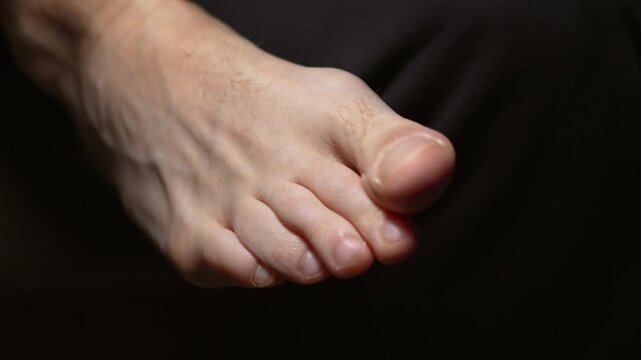 A human big toe.
A bare foot against a dark background.
A man wiggling his toes.
Anatomy, toe, body, nail, barefoot