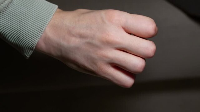 Fist cop plan.
Angry guy clenches his fist.