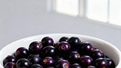 Bowl of fresh black currants on bright background