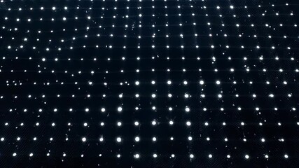 A dark surface with many white lights arranged in neat rows, perspective view