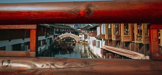 Selbstklebende Fototapeten Shanghai Framed view of a canal bridge with traditional houses and scenic reflections. Zhujiajiao, Shanghai, China  © Great Brut Here
