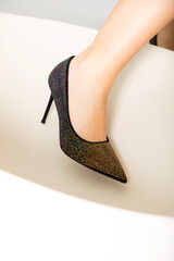 Elegant woman's leg in high heel shoe on white background, exuding luxury and sophistication.