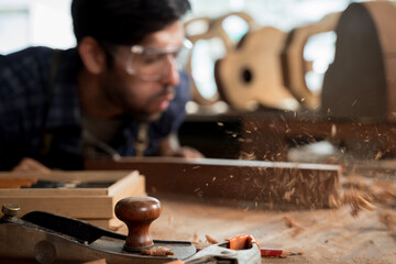 Woodworking Hand Plane with Flying Wood Shavings, Carpenter Blowing Dust in Workshop