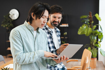 Business professional men collaborating on project using laptop together working in modern office