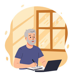 Elderly man writing notes while using laptop at home by the window  