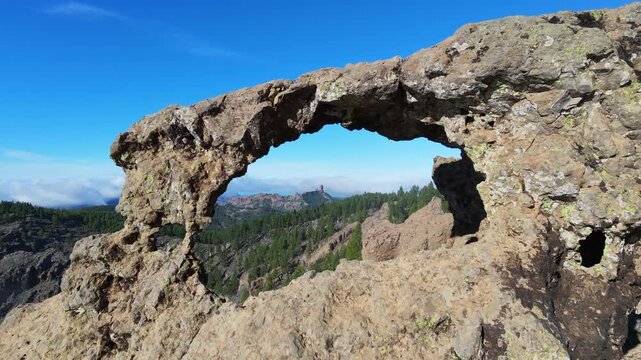 Aerial view through the Nublo window, showing Roque Nublo and the snow-capped Teide volcano. Gran Canaria.