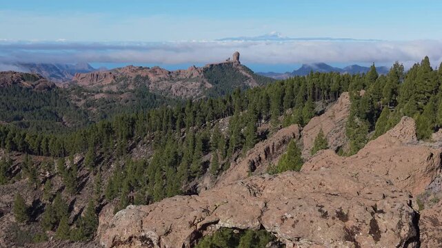 Aerial view discovering Roque Nublo and snowy Teide volcano through a natural rock arch (Ga&ntilde;ifa).