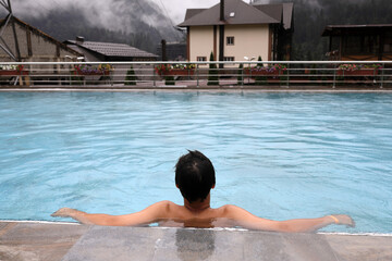 Boy relaxing in outdoor swimming pool