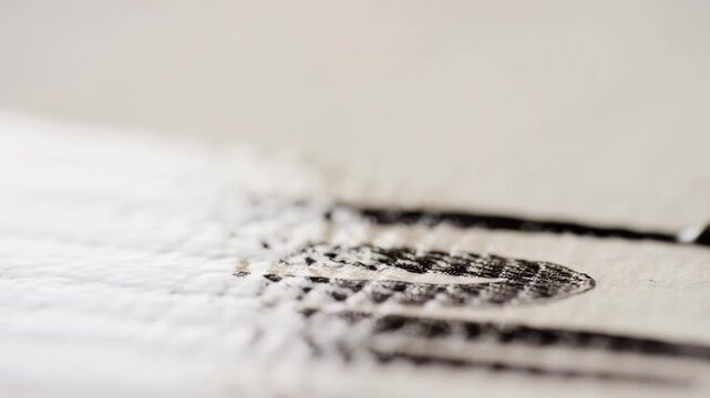 Closeup of ink pen writing on paper: calligraphy art in motion captured in detailed sequence