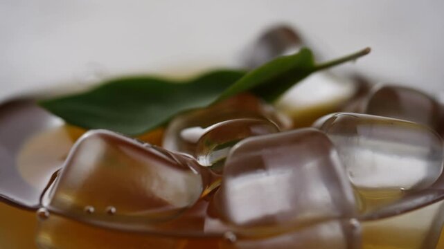 Ice cubes and leaf float in refreshing drink capturing cool harmony
