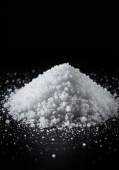 A close-up view of shimmering white sea salt crystals piled on a dark surface, highlighting the essential seasoning used in culinary preparation ,savory ,salted ,diet