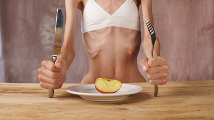  Skinny young woman with anorexia, bulimia at eating. Too little nutrition concept.