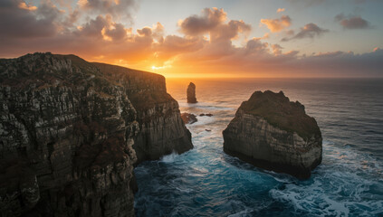Sunset ocean cliff rock sea stack dramatic light coastal sunrise warm sky